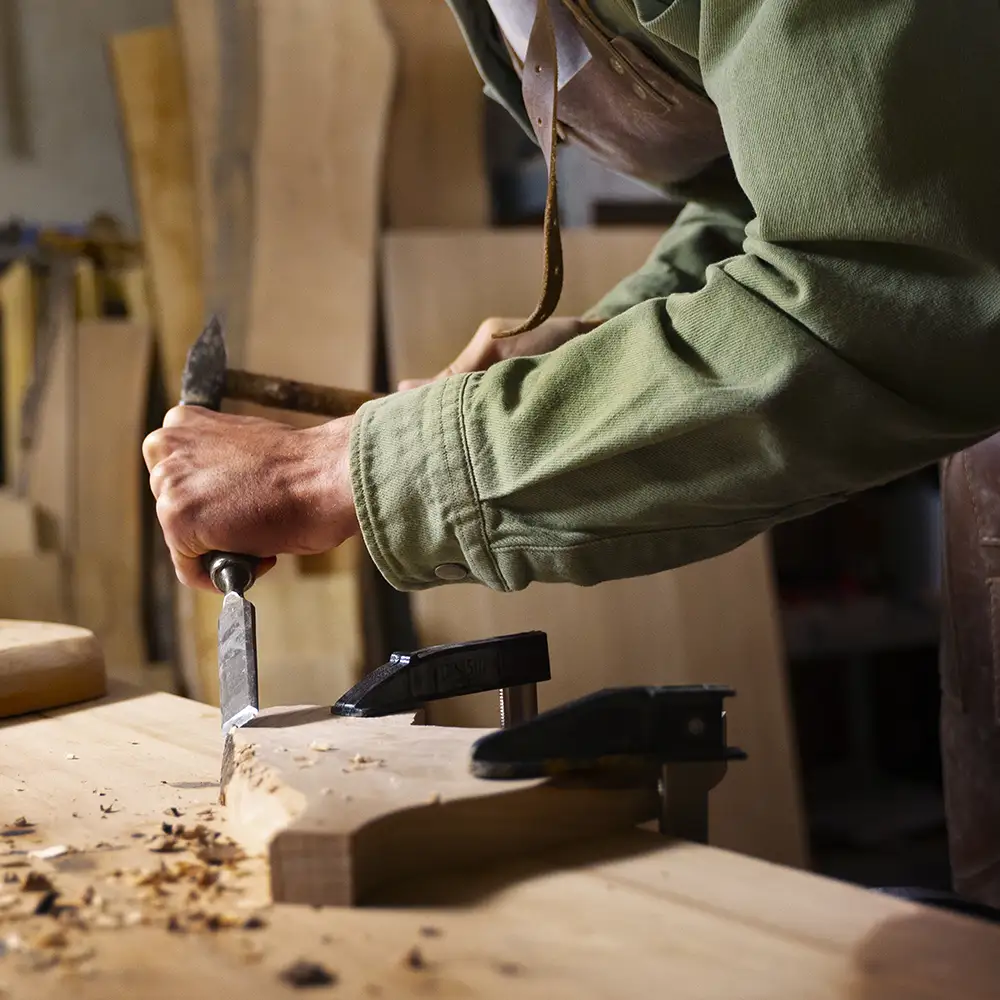 Frédéric travaillant le bois dans son atelier